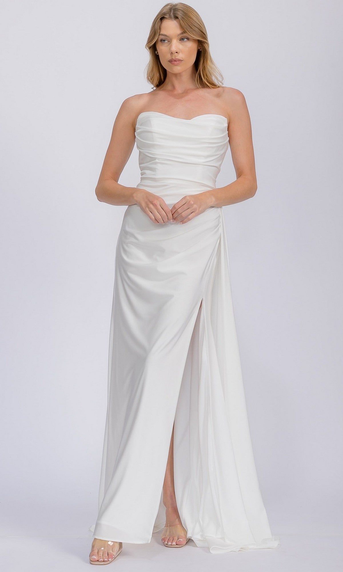 A woman in the Eureka EK178 long prom dress with a strapless, fitted bodice, ruched details, and a high slit stands against a plain light background.